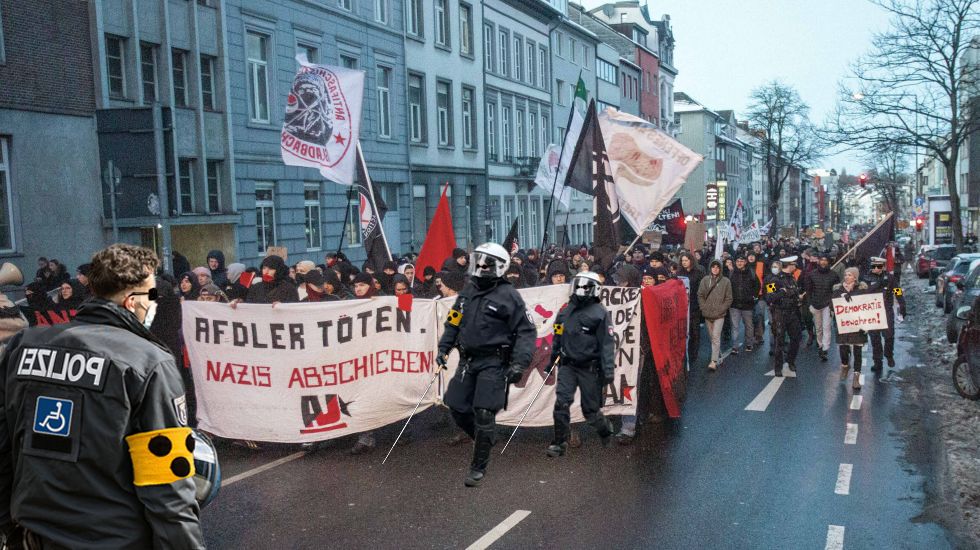 Polizeistaffel mit Blindenstöcken vor "AfDler töten." Transparent